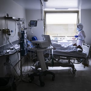Una enfermera atiende a un paciente en estado grave en una de las habitaciones de la UCI del Gregorio Marañón. El paciente le tumban hacia abajo para disminuir la presión sobre los pulmones y facilitar la respiración. 