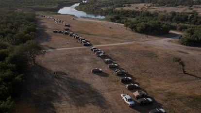 Vehículos militares y de las fuerzas del orden crean un cordón alrededor de los migrantes que se refugian en un campamento fronterizo improvisado en Del Rio, Texas.