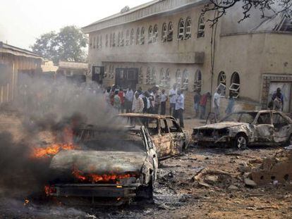 Un coche arde ante la iglesia de Madalla.