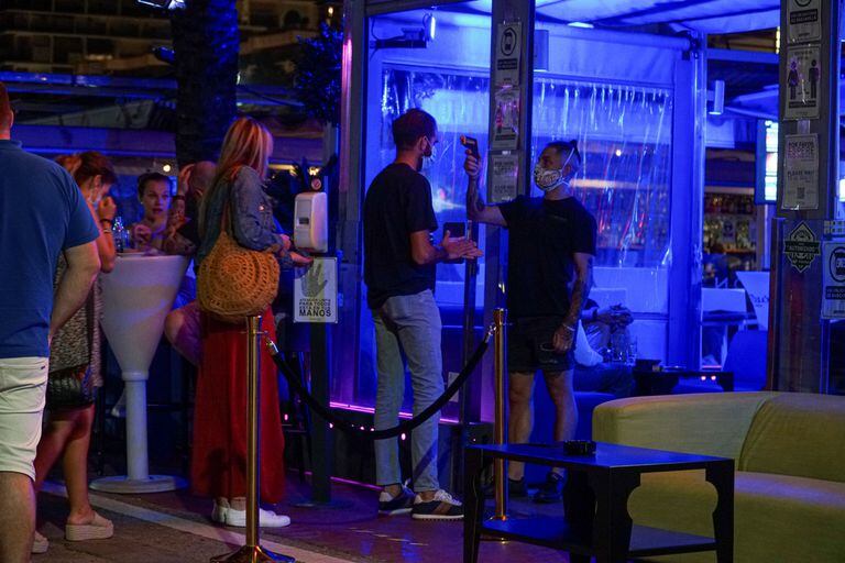 Un empleado toma la temperatura a un joven en la entrada de un pub de Marbella.