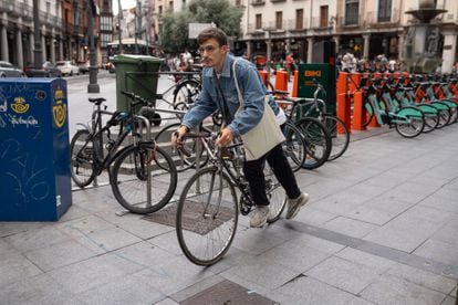 A young man takes his bike out of a parking lot in the center of Valladolid, on June 21, 2023.