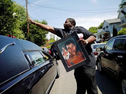 Un hombre lanza una rosa sobre el coche fúnebre que lleva los restos de Muhammad Ali, en Louisville (Estados Unidos).