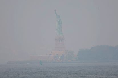 El humo de los incendios forestales canadienses cubren la Estatua de la Libertad, este jueves.