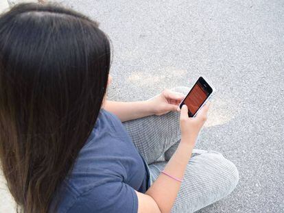 Una mujer usa su teléfono móvil. 