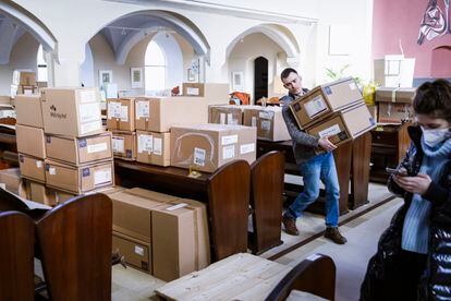 A volunteer loads boxes of medical supplies in the Philippus-Nathanael parish in Berlin that Oleksii and Thomas are going to take to the Polish-Ukrainian border with a car and a van. 
