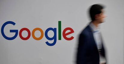 Una persona pasa junto a un logo de Google.