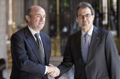 El presidente de la Generalitat de Cataluña, Artur Mas (derecha), saluda al ministro de Economía y Competitividad, Luis de Guindos.