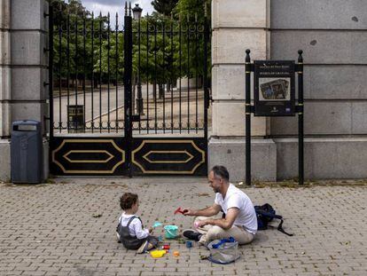 Un padre juega con su hijo en la calle (Madrid).