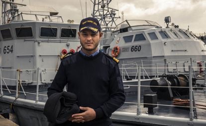 El comandante Nasser Al Gamudi posa frente a dos barcos donados por Italia a los guardacostas libios en el puerto de Trípoli, Libia.