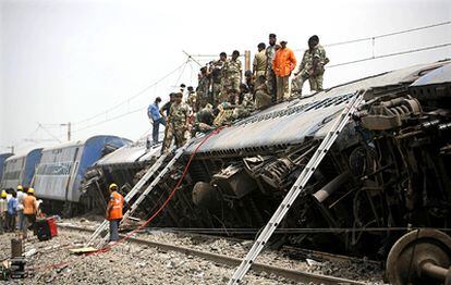 Efectivos del Ejército indio realizan labores de rescate en uno de los vagones del tren descarrilado por el atentado.