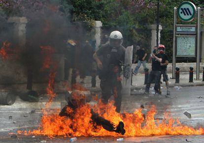 Un policía antidisturbios se revuelve en medio de las llamas de un cóctel molotov lanzado durante las protestas frente al Parlamento en Atenas.