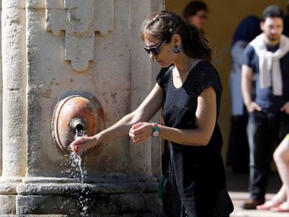 Una turista se refresca en una fuente en Córdoba.
