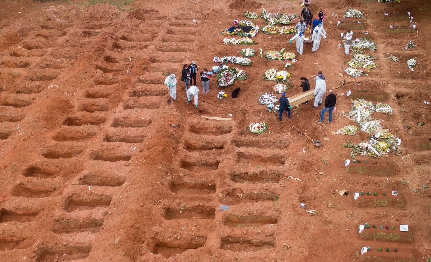 Los trabajadores del cementerio entierran a tres víctimas de coronavirus en el cementerio de Vila Formosa, en Sao Paulo, Brasil.