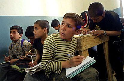 Unos niños afganos copian apuntes de la pizarra en una escuela cerca de la base de Bagram.