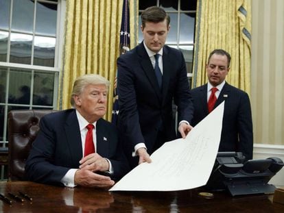 Porter entrega un documento a Trump el 20 de enero de 2017, en sus primeras horas como presidente