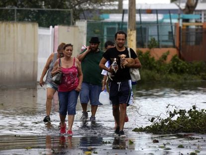 Unas personas caminan por una calle inundada de la isla.