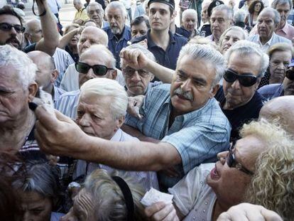Pensionistas aguardan su turno ante una sucursal bancaria en Atenas.