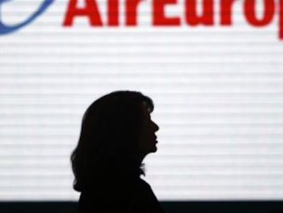 Una mujer pasa ante una pantalla con el logotipo de Air Europa en al terminal 2 de Barajas.