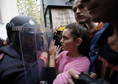 La policia evita amb escuts que la gent s'apropi a una mesa de votació a Barcelona.