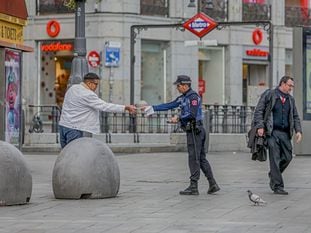 Un policía municipal de Madrid pone una multa a un viandante por no respetar la cuarentena en Madrid.