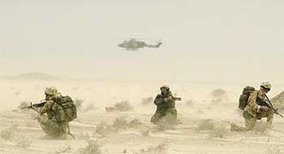 Soldados del 16º Batallón de Asalto Aerotransportado británico patrullan ayer campos petrolíferos en el norte de Ramelia, en medio de una fuerte tormenta de arena.