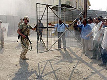 Un grupo de soldados británicos, ante varios manifestantes que reclaman electricidad, agua corriente y combustible, ayer en Basora, en el sur de Irak.