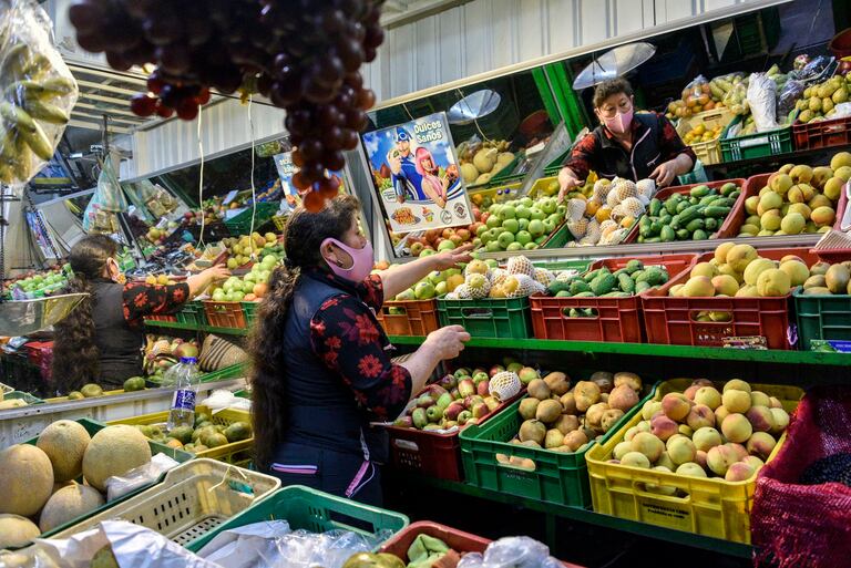 Una mujer coloca las frutas en su puesto del mercado en Corabastos, Bogotá, Colombia.
