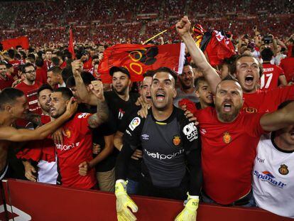 El portero del RCD Mallorca, Manolo Reina, celebra el ascenso de su equipo junto a aficionados en el esadio de Son Moix.