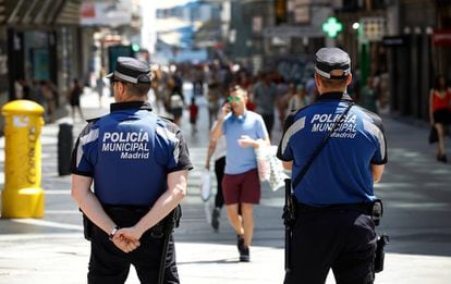 Dos polic&iacute;as municipales vigilan la calle de Preciados.