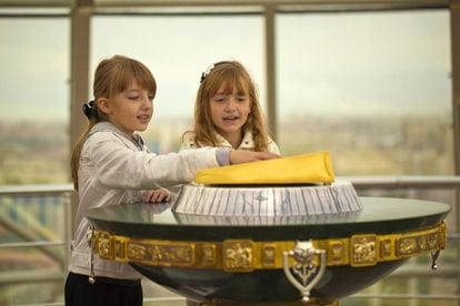 Una niña pone la mano sobre la huella dorada de Nursultán Nazarbáyev en un monumento en la capital de Kazajistán, mientras pide un deseo.