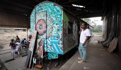 Varios artistas del colectivo BSQ trabajan frente a un vagón de tren abandonado y convertido en estudio de arte en el centro de Nairobi, Kenia, el 20 de agosto de 2019.