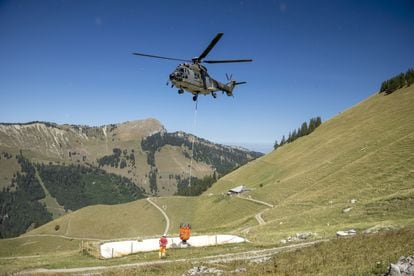 Un helicóptero de la Fuerza Aérea Suiza transporta agua para las vacas en el pasto de la montaña Tissiniva, en Charmey (Suiza), el miércoles.