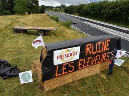 Un cartel con el lema &quot;President arruina a los ganaderos&quot;, en protesta por el bajo precio de la leche, en una carretera de Le Mans (Francia), el viernes pasado. 