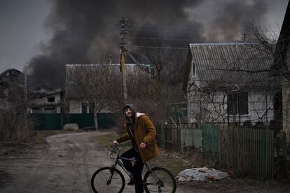 Un joven en bicicleta durante los bombardeos en Irpin, este domingo.