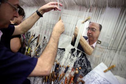José Antonio "Pepe" Carbajal, de 59 años, teje un tapiz junto a su compañera de trabajo Cristina Hurtado, de 33 años.