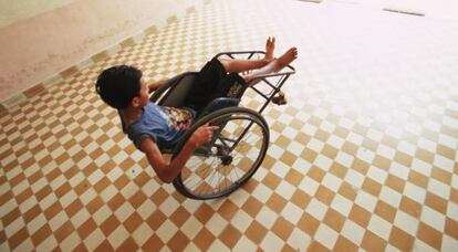 Un niño con discapacidad juega con su silla de ruedas.