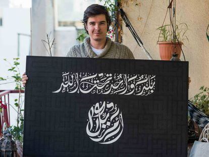 El calígrafo y artista norteamericano Everitte Barber muestra en su estudio de Beirut una de sus obras en la que recurre al juramento a la bandera de EE UU para mimetizar a la del Estado Islámico.