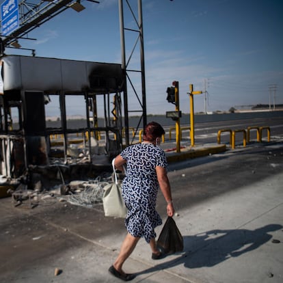 A woman walks along the Pan-American highway during a road blockade in the framework of a partial strike of cargo and passenger carriers, in Ica, in southern Peru, on April 4, 2022. - A partial strike of cargo and passenger carriers caused road blockades and suspension of classes in Peru, in the first strike against the government of leftist President Pedro Castillo. (Photo by Ernesto BENAVIDES / AFP)