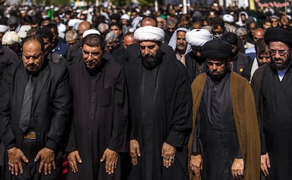 Un grupo de clérigos y dirigentes chiíes rezan en el camino a Nayaf. Los chiíes oran con los brazos extendidos y los suníes con los brazos cruzados.