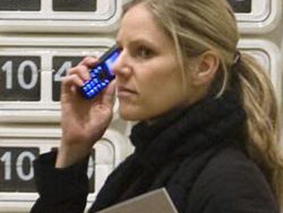 Una mujer habla por teléfono en una exposición de arte.