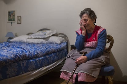 Carmen Martinez Ayuso llora en una habitación de la vivienda que lleva 50 años habitando. Su marido falleció por un cáncer de garganta hace siete años.