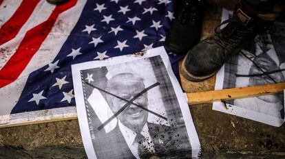 Palestinos pisan banderas estadounidenses y una foto del presidente de Ee UU, Donald Trump, durante una protesta en el norte de la Franja de Gaza (Palestina) el 7 de diciembre de 2017. 