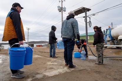 A group stands in line to fetch water from a tanker on Thursday.