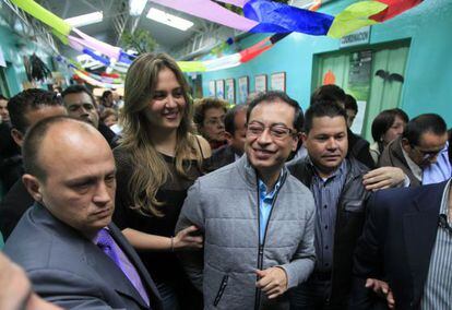 El nuevo alcalde de Bogotá, Gustavo Petro, junto a su mujer (a la izquierda de la imagen) en el centro electoral.