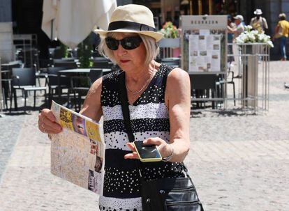 Una turista sujeta en una mano un plano de Madrid y en la otra un móvil, en centro de la capital.