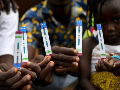 Una familia de Costa de Marfil enseña los resultados de los test de VIH. 