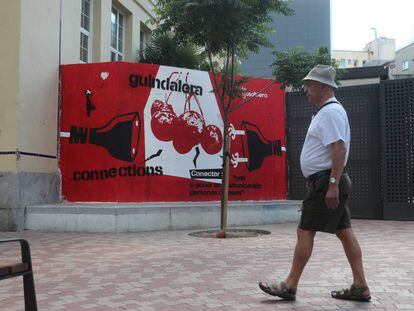 Un hombre pasea frente a un mural del espacio vecinal 'La Gasolinera', en Madrid.