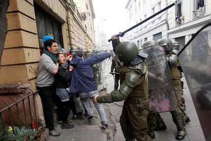 La policía antidisturbios golpea a unos estudiantes durante el segundo día de protestas en Santiago de Chile contra el impopular presidente del país, Sebastián Piñera