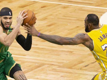Jayson Tatum trata de zafarse de LeBron James.