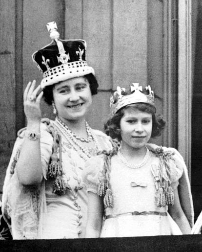 La reina madre, que porta la Corona de Isabel, donde está engarzado el diamante Koh-i-Noor, saluda desde el balcón del Palacio de Buckingham junto a la entonces princesa Isabel, en un acto de apertura del Parlamento Británico.